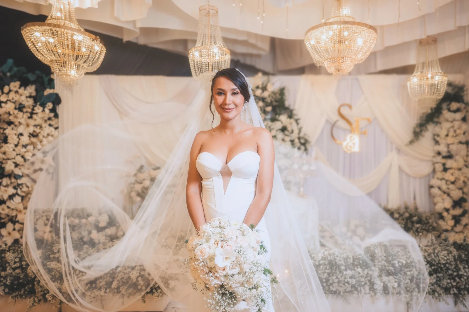 Novios besándose junto a un carruaje blanco